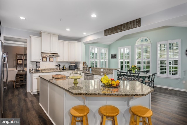 10437 Windlass Run Rd, Baltimore, MD 21220 - kitchen featuring stainless steel appliances, under cabinet range hood, white cabinetry, and a kitchen breakfast bar