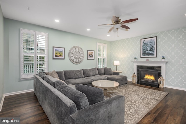 10437 Windlass Run Rd, Baltimore, MD 21220 - living area with dark wood-type flooring, a fireplace with flush hearth, a ceiling fan, wallpapered walls, and baseboards