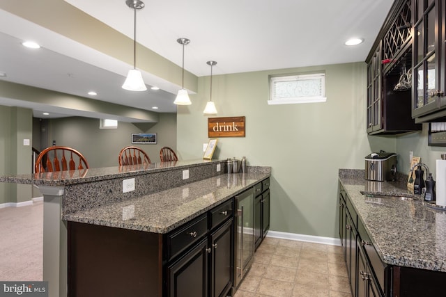 10437 Windlass Run Rd, Baltimore, MD 21220 - kitchen with a peninsula, dark stone countertops, a sink, decorative light fixtures, and baseboards