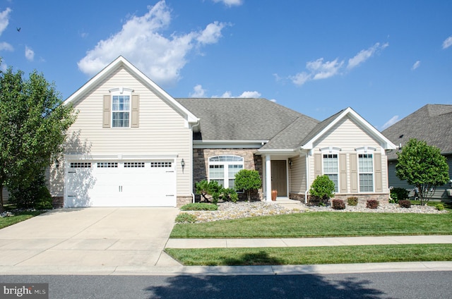 traditional home with a shingled roof, a front yard, a garage, stone siding, and driveway