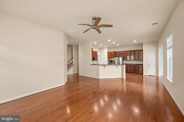 unfurnished living room with recessed lighting, baseboards, and dark wood finished floors