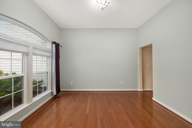 unfurnished room with baseboards and wood finished floors