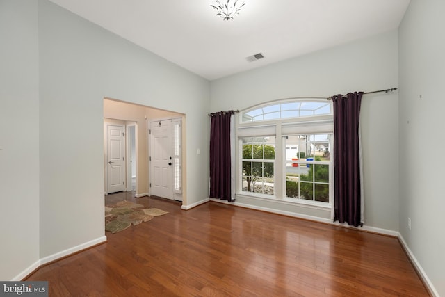 unfurnished room featuring visible vents, baseboards, and wood finished floors