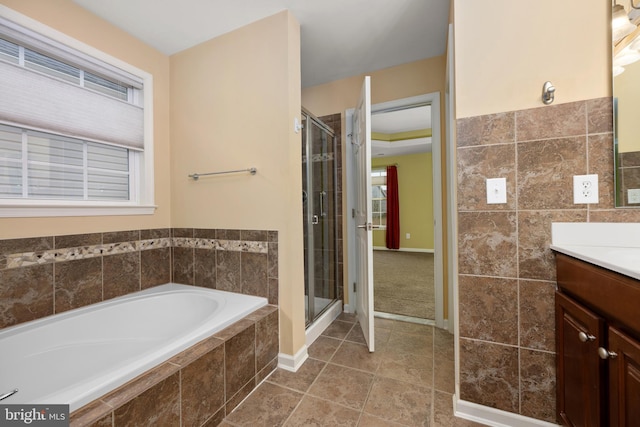 bathroom with a bath, tile patterned flooring, a stall shower, and vanity