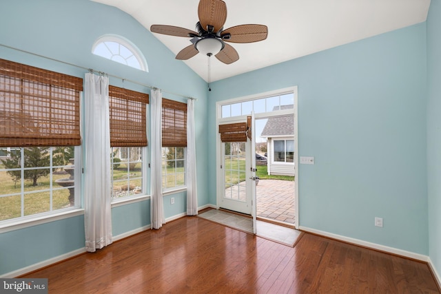 interior space with vaulted ceiling, a healthy amount of sunlight, a ceiling fan, and wood finished floors