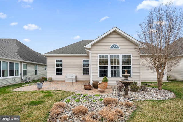 rear view of property featuring a patio area, a shingled roof, and a yard