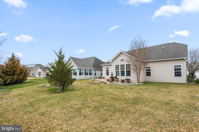 rear view of property featuring a yard