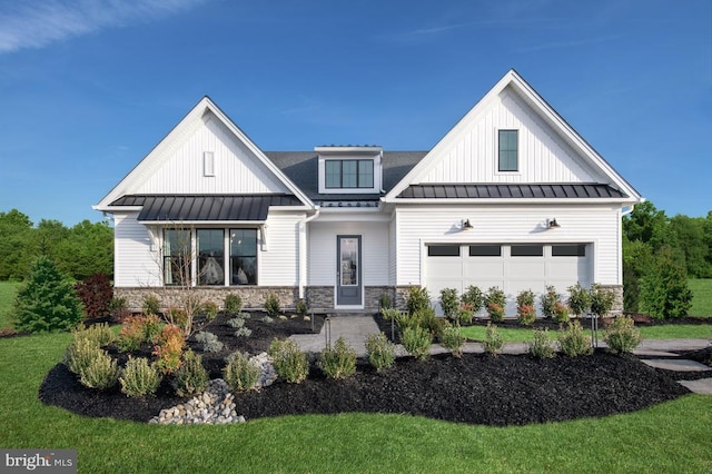 modern farmhouse style home featuring board and batten siding, a front yard, metal roof, stone siding, and a standing seam roof