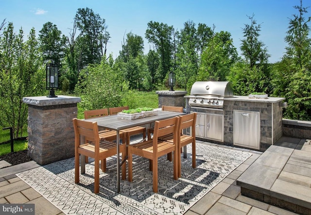 view of patio with grilling area, outdoor dining area, and exterior kitchen