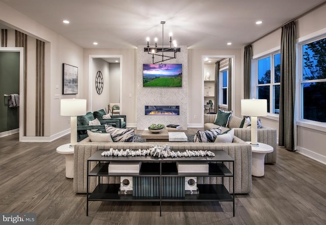 living area with recessed lighting, wood finished floors, baseboards, and a chandelier