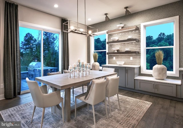 dining area with dark wood-type flooring, a notable chandelier, and recessed lighting