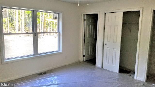 unfurnished bedroom with a closet and visible vents