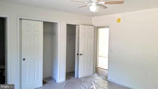 unfurnished bedroom featuring baseboards and two closets