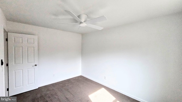 spare room with a ceiling fan and baseboards