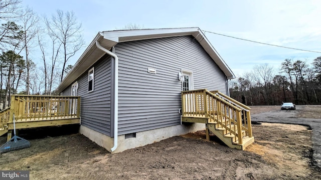 view of property exterior featuring crawl space and a deck