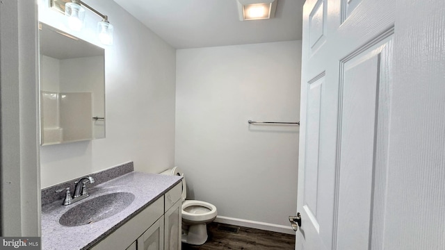 bathroom with visible vents, baseboards, toilet, wood finished floors, and vanity