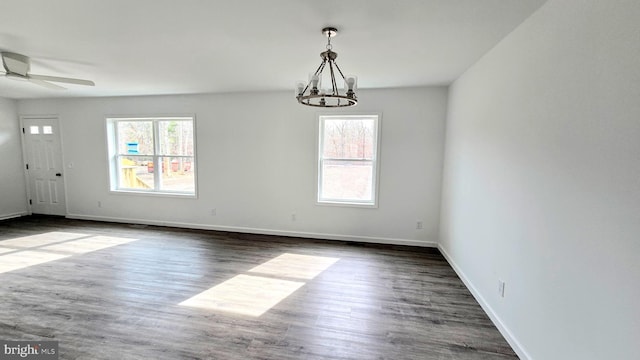 spare room with a wealth of natural light, baseboards, and dark wood-style floors