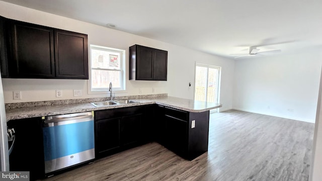 kitchen featuring dishwashing machine, a peninsula, a wealth of natural light, and a sink