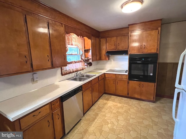 kitchen with black appliances, light countertops, under cabinet range hood, and a sink