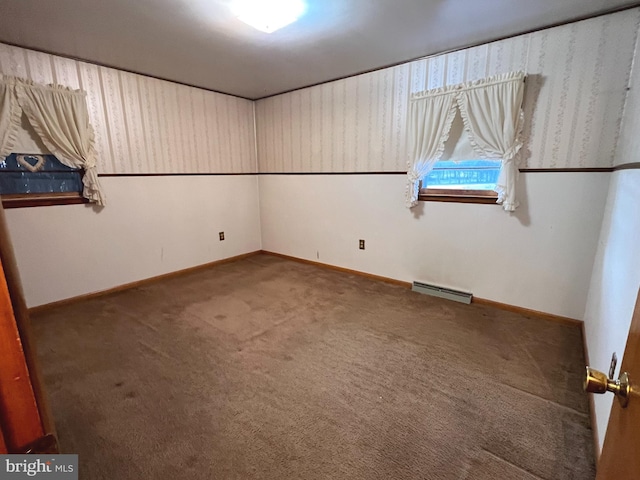 unfurnished bedroom featuring baseboards, a baseboard heating unit, and carpet