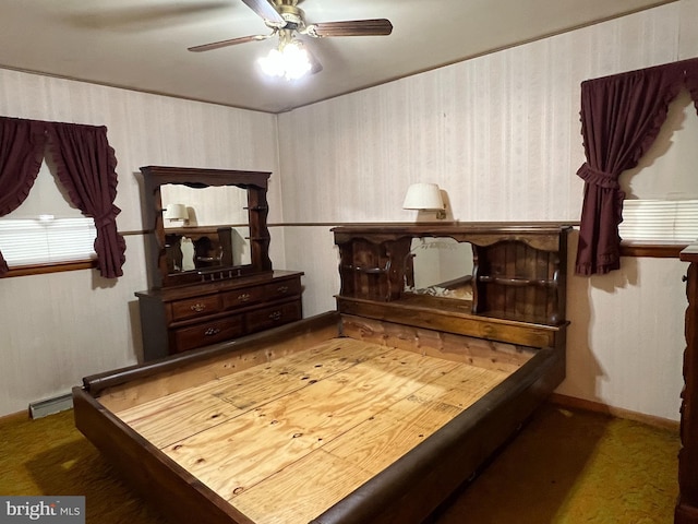 bedroom with a baseboard heating unit, baseboards, carpet flooring, and a ceiling fan