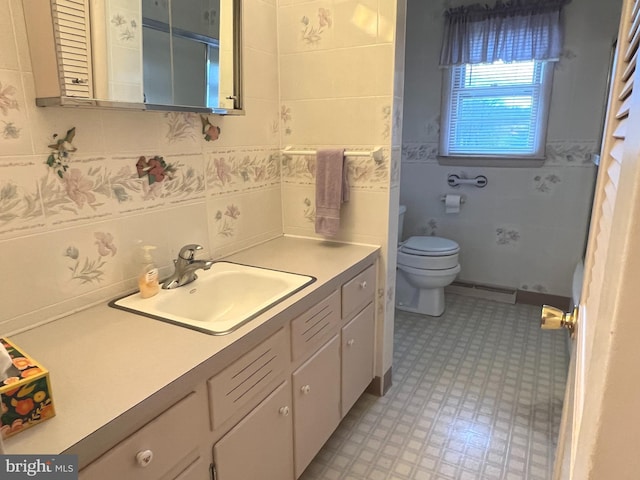 bathroom featuring toilet, vanity, tile patterned floors, tile walls, and a baseboard radiator