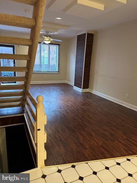 unfurnished room with stairway, baseboards, wood finished floors, and a ceiling fan