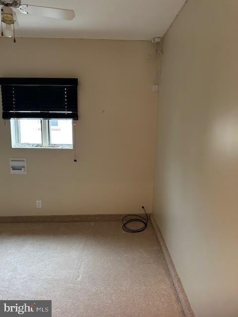 spare room featuring ceiling fan and baseboards