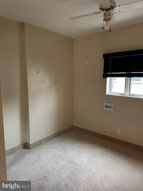 empty room with baseboards and a ceiling fan