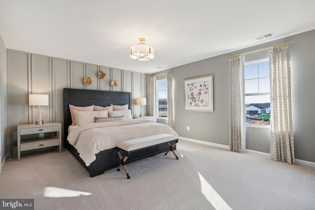 bedroom with visible vents, light colored carpet, and baseboards