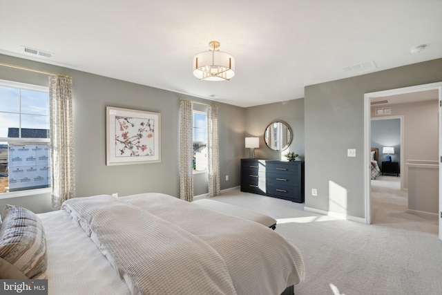 bedroom with visible vents, baseboards, and light colored carpet