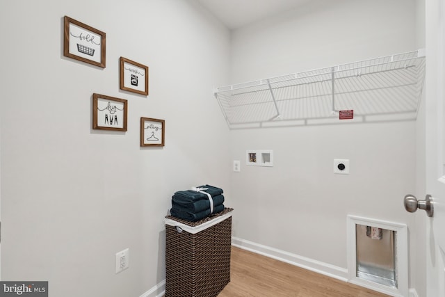 clothes washing area featuring laundry area, hookup for a washing machine, electric dryer hookup, and baseboards