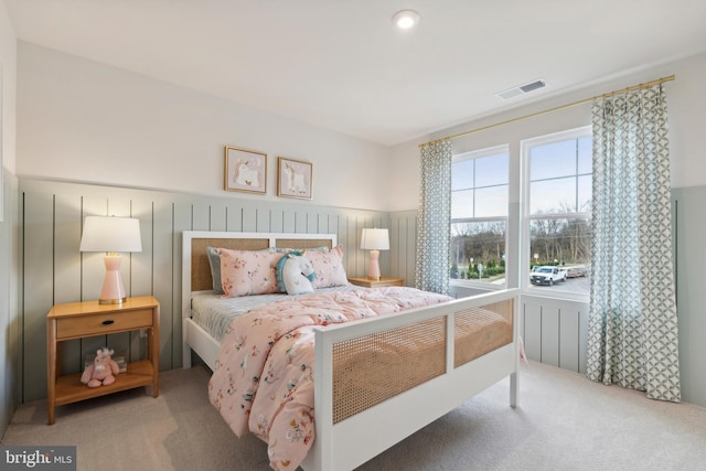 carpeted bedroom featuring visible vents and wainscoting