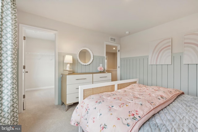 bedroom featuring visible vents, light colored carpet, a closet, and a spacious closet