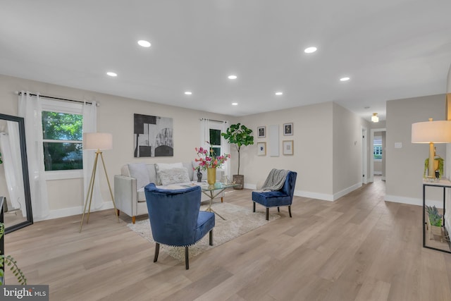 living area with recessed lighting, light wood-type flooring, and baseboards