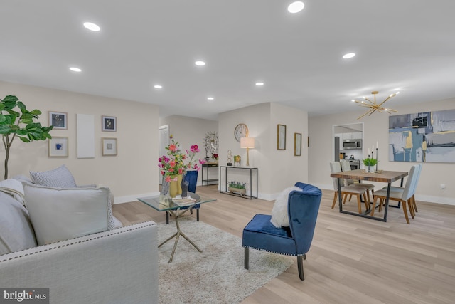 living area with recessed lighting, a chandelier, baseboards, and light wood-style flooring