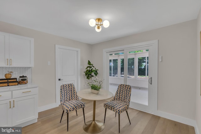 dining area featuring light wood-style flooring and baseboards