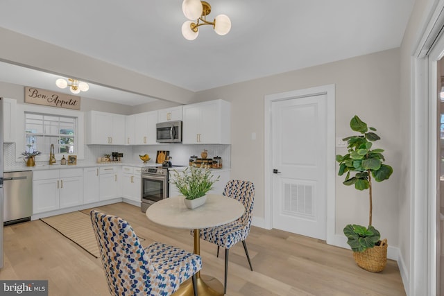 kitchen featuring tasteful backsplash, visible vents, stainless steel appliances, and light countertops