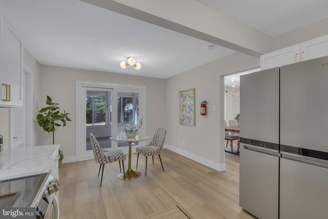 dining area with baseboards and light wood finished floors