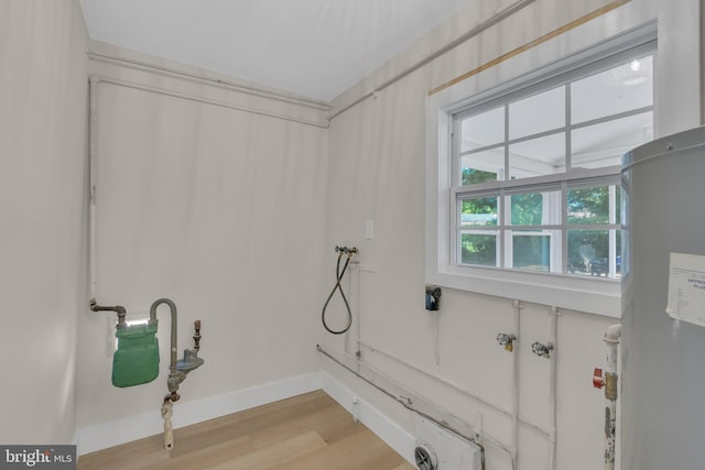 bathroom featuring wood finished floors, water heater, and baseboards