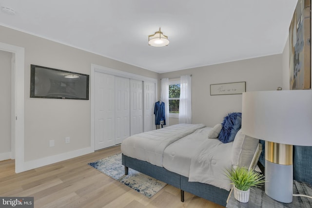 bedroom featuring a closet, baseboards, and wood finished floors