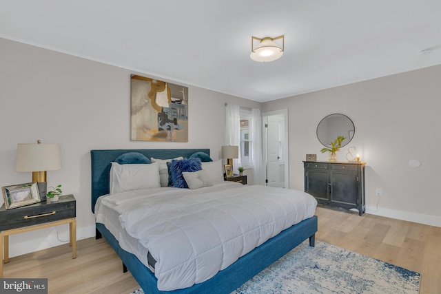 bedroom with baseboards and light wood finished floors