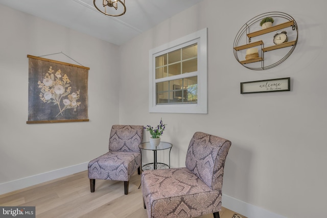 living area with baseboards and wood finished floors