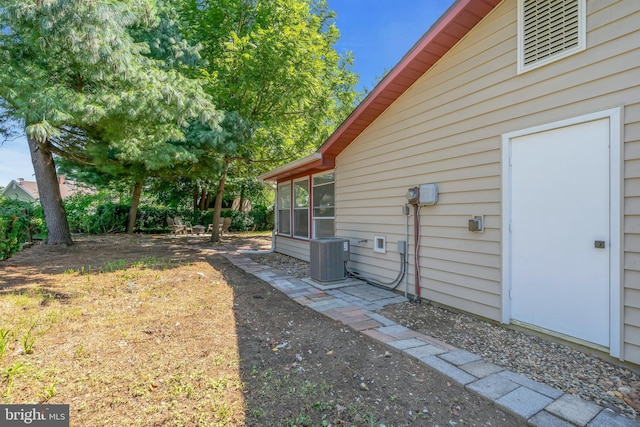 view of yard with central AC and a sunroom