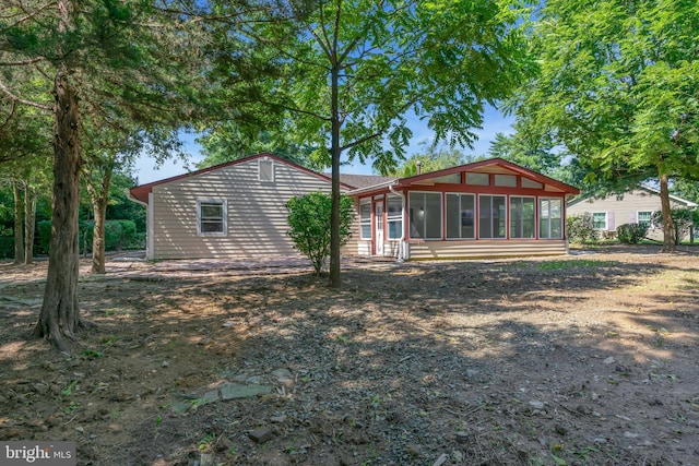 rear view of property featuring a sunroom