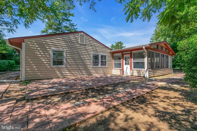 view of front of house featuring a sunroom and a patio area