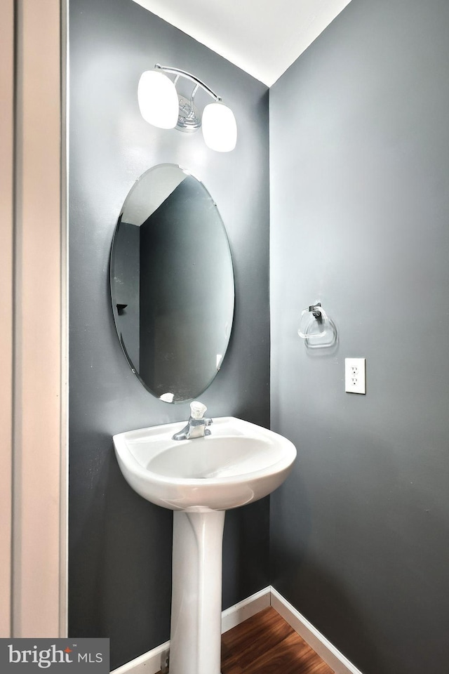 bathroom featuring a sink, baseboards, and wood finished floors