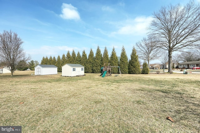 view of yard with an outbuilding, a storage unit, and a playground