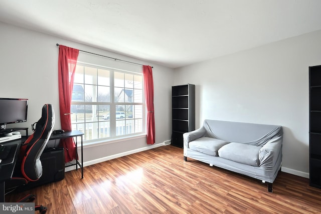 home office with a baseboard radiator, baseboards, and wood finished floors