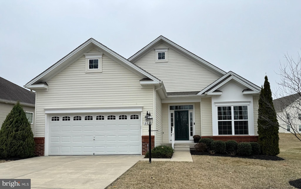 view of front of house with an attached garage, brick siding, and driveway